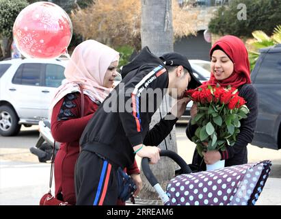 220214 -- BEIRUT, 14. Februar 2022 -- Ein Mann riecht am Valentinstag an der Küste von Beirut, Libanon, am 14. Februar 2022 Blumen. LEBANON-BEIRUT-VALENTINE S DAY LiuxZongya PUBLICATIONxNOTxINxCHN Stockfoto