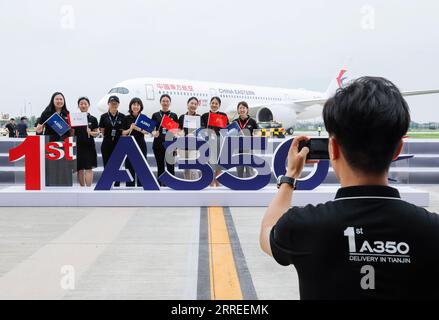 210721 -- TIANJIN, 21. Juli 2021 -- Mitarbeiter posieren für ein Gruppenfoto vor einem Airbus A350 Flugzeug, das an China Eastern Airlines im Airbus Tianjin Widebody Completion and Delivery Center im nordchinesischen Tianjin, 21. Juli 2021 geliefert wurde. Airbus hat sein A350-Flugzeugprojekt in seinem Großraumfertigstellungs- und Lieferzentrum im nordchinesischen Tianjin eingeweiht. Es ist das erste Mal, dass der europäische Planer ein solches Projekt für die A350 außerhalb Europas ins Leben gerufen hat. CHINA-TIANJIN-AIRBUS-A350-LIEFERUNG CN ZHANGXYUWEI PUBLICATIONXNOTXINXCHN Stockfoto