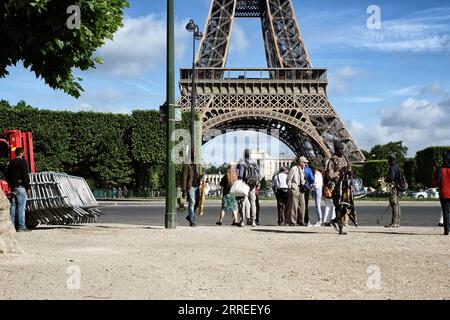Am Morgen auf den Champs de Mars, Paris, Frankreich, arbeiten Straßenverkäufer und Souvenirverkäufer daran, Andenken an den Eiffelturm an Touristen zu verkaufen Stockfoto