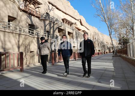 220301 -- DUNHUANG, 1. März 2022 -- Su Bomin R, zusammen mit Technikern der Dunhuang Academy, besuchen die Mogao Grotten in Dunhuang, nordwestchinesische Provinz Gansu, 23. Februar 2022. SU Bomin, Abgeordneter des Nationalen Volkskongresses NPC, ebenfalls Dekan der Dunhuang Academy, arbeitet seit drei Jahrzehnten in den Mogao Grotten, einem UNESCO-Weltkulturerbe in Dunhuang, der nordwestchinesischen Provinz Gansu. Seit Beginn seines Dienstes als NPC-Stellvertreter hat Su eine Reihe von Vorschlägen zum Schutz kultureller Reliquien vorgelegt. Während der beiden Sitzungen des Jahres, der jährlichen Sitzungen der Nation Stockfoto