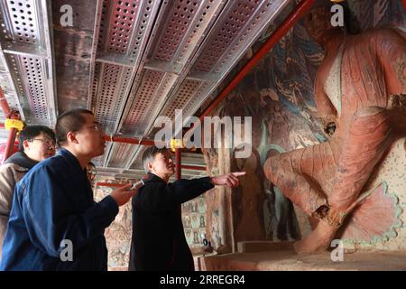 220301 -- DUNHUANG, 1. März 2022 -- Su Bomin 1st R überprüft die Restaurierung von Wandmalereien und Skulpturen in den Mogao Grotten in Dunhuang, nordwestchinesische Provinz Gansu, 23. Februar 2022. SU Bomin, Abgeordneter des Nationalen Volkskongresses NPC, ebenfalls Dekan der Dunhuang Academy, arbeitet seit drei Jahrzehnten in den Mogao Grotten, einem UNESCO-Weltkulturerbe in Dunhuang, der nordwestchinesischen Provinz Gansu. Seit Beginn seines Dienstes als NPC-Stellvertreter hat Su eine Reihe von Vorschlägen zum Schutz kultureller Reliquien vorgelegt. Während der beiden Sitzungen des Jahres, der jährlichen Sitzungen der Natio Stockfoto