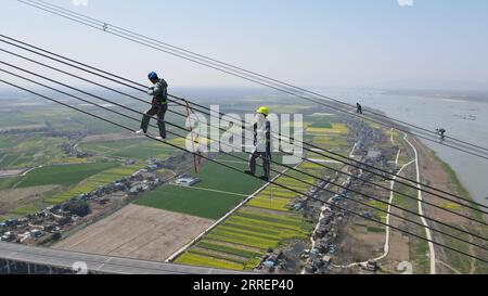 220311 -- CHIZHOU, 11. März 2022 -- Luftaufnahme vom 10. März 2022 zeigt Elektriker, die an der 800-Kilovolt-Gleichstromleitung Lingzhou-Shaoxing über den Yangtze in Chizhou, der ostchinesischen Provinz Anhui, arbeiten. In einer Höhe von bis zu 280 Metern über dem Yangtze-Fluss in Chizhou, der ostchinesischen Provinz Anhui, hat ein Team von Technikern kürzlich eine Überholung der 800-Kilovolt-Gleichstromleitung von Lingzhou-Shaoxing durchgeführt. Das UHV-Kraftübertragungsprojekt für ultrahohe Spannungen erstreckt sich von Lingzhou im Nordwesten Chinas Ningxia Hui Autonomous Region al Stockfoto