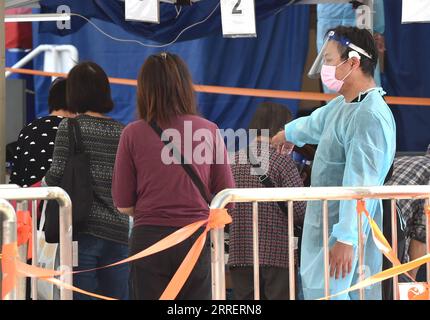 220314 -- HONGKONG, 14. März 2022 -- Ein medizinischer Arbeiter führt Bürger an einem mobilen Nukleinsäuretestplatz in Hongkong, Südchina, 14. März 2022. Am Montag registrierte Hongkong 12.040 neue COVID-19-Fälle durch Nukleinsäure-Tests und 14.868 weitere positive Fälle durch selbst berichtete Antigen-Schnelltests, wie offizielle Daten zeigten. CHINA-HONGKONG-COVID-19-FÄLLE CN LOXPINGXFAI PUBLICATIONXNOTXINXCHN Stockfoto