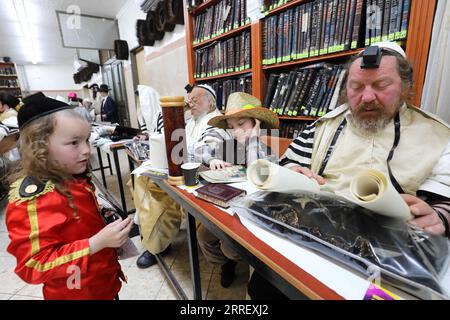 220318 – JERUSALEM, 18. März 2022 – Ultra-orthodoxe Juden lasen das Buch Esther während des jüdischen Purim-Feiertags in einer Synagoge in Jerusalem am 18. März 2022. Purim ist ein jüdischer Feiertag, der an die Befreiung des jüdischen Volkes von Hamans Verschwörung während der Herrschaft des alten Persischen Reiches erinnert, wie aus dem biblischen Buch Esther hervorgeht. Foto von /Xinhua MIDEAST-JERUSALEM-PURIM-ESTHER-READING GilxCohenxMagen PUBLICATIONxNOTxINxCHN Stockfoto