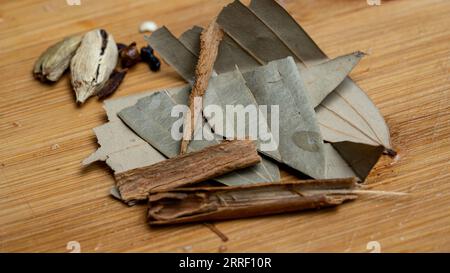 Schließen Sie Lorbeerblatt Zimt und Kardamom auf hölzernem Hintergrund Stockfoto