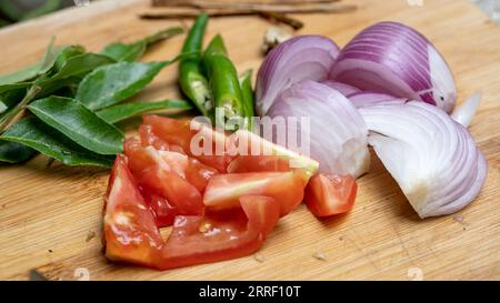 Nahaufnahme des Schneidebretts mit geschnittenen Tomaten und Zwiebeln. Stockfoto