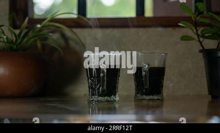 Zwei schwarze Kaffeetassen in der Küchenzeile Stockfoto