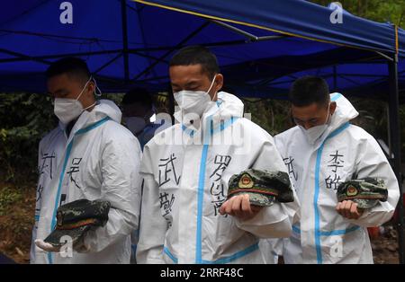 220327 -- TENGXIAN, 27. März 2022 -- Foto aufgenommen am 27. März 2022 zeigt eine Gedenkveranstaltung am Absturzort des Flugzeugs der China Eastern Airlines, um den Tod von 132 Menschen zu betrauern, die an dem Unfall im Tengxian County, der südchinesischen autonomen Region Guangxi Zhuang, beteiligt waren. Gegen 14 Uhr, als das Geräusch der Hörner in einem bergigen Gebiet im Tengxian County ertönte, standen alle Mitarbeiter der nationalen Notfallzentrale für den Unfall und die Rettungskräfte vor Ort feierlich drei Minuten lang still, um den Opfern zu gedenken. CHINA-GUANGXI-TENGXIAN-FLUGZEUGABSTURZSTELLE-MOURNI Stockfoto