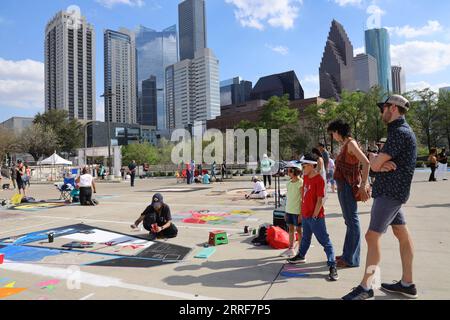 220403 -- HOUSTON, 3. April 2022 -- Menschen beobachten, wie ein Künstler in einem Street Painting Chalk Art Festival in Houston, Texas, USA, am 2. April 2022 malt. Foto von /Xinhua U.S.-TEXAS-HOUSTON-STREET PAINTING CHALK ART FESTIVAL XuxJianmei PUBLICATIONxNOTxINxCHN Stockfoto