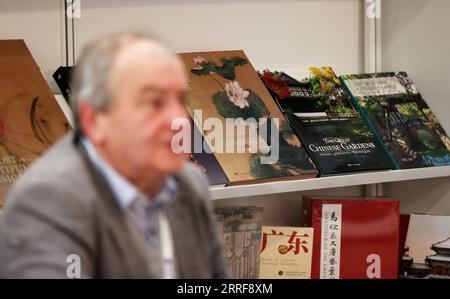 220406 -- LONDON, 6. April 2022 -- A man Talks at A Stand of Chinese Books at London Book Fair in London, Großbritannien, 5. April 2022. Die erste persönliche London Book Fair, eine der weltweit größten Verlagsmessen, startete hier am Dienstag nach Aussetzungen aufgrund der COVID-19-Pandemie seit 2019. Die 1971 gestartete Messe wird bis Donnerstag mit mehr als 900 Ausstellern stattfinden. BRITANNIEN-LONDON-BUCHMESSE LixYing PUBLICATIONxNOTxINxCHN Stockfoto