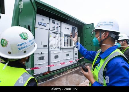 220408 -- HONGKONG, 8. April 2022 -- Ein Arbeiter spricht per Videolink über die Stromübertragung auf der Baustelle eines Notfallkrankenhausprojekts, unterstützt von Chinas zentralen Behörden im Lok Ma Chau Loop-Gebiet in Hongkong, Südchina, 29. März 2022. Die Anlagen, die in der ersten Bauphase eines Notfallkrankenhausprojekts errichtet wurden, wurden am Donnerstag mit Unterstützung der chinesischen Zentralbehörden den zuständigen Abteilungen in der Sonderverwaltungsregion Hongkong übergeben. Die fertiggestellten Einrichtungen bestehen aus 500 Unterdruckbetten, darunter 32 Intensivstationen und zwei Operationsstationen Stockfoto