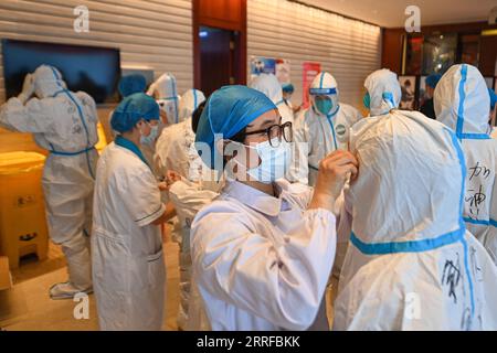 220411 -- HANGZHOU, 11. April 2022 -- Sanitäter ziehen Schutzanzüge in einem Quarantänehotel in Hangzhou, ostchinesische Provinz Zhejiang, 11. April 2022 an. Die Stadt Hangzhou hat Quarantänezimmer angeboten, um Shanghai während seines COVID-19-Wiederauflebens zu helfen. Die Räume werden genutzt, um Personen zu isolieren, die enge Kontakte und sekundäre enge Kontakte zu COVID-19-Fällen in Shanghai haben. Die humanistische Versorgung wurde an isolierten Standorten verstärkt, wobei der Schwerpunkt auf der Sicherheit des Lebens, medizinischen Dienstleistungen, psychischen Gesundheitsberatung und personalisierten Dienstleistungen liegt. CHINA-ZHEJIANG-HANGZHOU-COVID-19-QUARANTINE CN JIANGXHAN VERÖFFENTLICHUNG Stockfoto