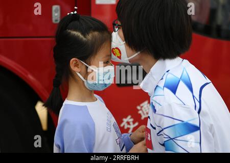 Coronavirus, Eindrücke aus China 220411 -- TIANJIN, 11. April 2022 -- Xu Ning küsste ihre Tochter, bevor sie am 11. April 2022 nach Shanghai, im nordchinesischen Tianjin, ging. Tianjin entsandte am Montag ein Team von 78 medizinischen Fachkräften aus der traditionellen chinesischen Medizin, um Shanghai bei der Bekämpfung der COVID-19-Pandemie zu unterstützen. Xu Ning, stellvertretender Chefarzt des ersten Lehrkrankenhauses der Tianjin Universität für traditionelle Chinesische Medizin, ist einer von ihnen. In den letzten zwei Jahren war sie viele Male in den Abteilungen des Tianjin Haihe Krankenhauses, um die Pandemie zu bekämpfen, und sammelte viel Erfahrung in der TCM-Behandlung Stockfoto