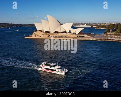 Sydney Australien / Ein Sydney Sightseeing Fantasea Kreuzfahrtschiff passiert das Sydney Opera House. Das Fantasea Hopper Cruise Boat fährt zum Circular Quay Stockfoto