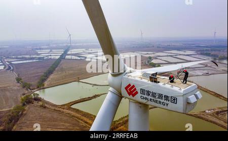 220414 -- TIANJIN, 14. April 2022 -- in diesem Luftbild untersuchen Techniker eine Windkraftanlage in Binhai New Area, nordchinesisches Tianjin, 11. April 2022. Die installierte Gesamtkapazität der Windparks in Tianjin beträgt bis Ende Februar dieses Jahres 1,296 Millionen Kilowatt. CHINA-TIANJIN-WINDKRAFT CN SunxFanyue PUBLICATIONxNOTxINxCHN Stockfoto