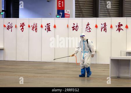 220414 -- SHANGHAI, 14. April 2022 -- Ein Mitarbeiter desinfiziert einen Bereich im Veranstaltungszentrum, das zum provisorischen Krankenhaus im Shanghai New International Expo Center SNIEC wurde, in Shanghai, Ostchina, 14. April 2022. Das vom Kongresszentrum umgebene provisorische Krankenhaus bietet Platz für mehr als 14.000 Betten, und medizinische Mitarbeiter, die im Krankenhaus arbeiten, kommen aus verschiedenen Provinzen und Städten wie Hubei, Tianjin und Jiangxi. Über 9.000 COVID-19-Patienten wurden am Donnerstag aus dem SNIEC entlassen. CHINA-SHANGHAI-SNIEC-MAKESHIFT KRANKENHAUS CN JINXLIWANG PUBLICATIONXNOTXINXCHN Stockfoto