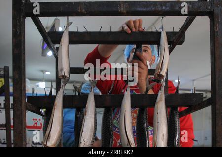 220420 -- GAZA, 20. April 2022 -- Ein Palästinenser bereitet am 20. April 2022 geräucherten Fisch auf einem Markt vor Eid al-Fitr im südlichen Gazastreifen Rafah zu. Foto von /Xinhua MIDEAST-GAZA-RAFAH-EID AL-FITR-PRÄPARAT RizekxAbdeljawad PUBLICATIONxNOTxINxCHN Stockfoto