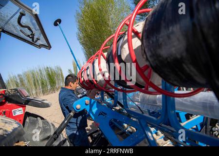 220422 -- SHAWAN, 22. April 2022 -- Ili Mehmet arbeitet an der Sämaschine in seinem Baumwollfeld in Shawan, Nordwestchina, Xinjiang Uygur Autonomous Region, 16. April 2022. Ili Mehmet, 50, lebt in Shawan, einem großen Baumwollanbaugebiet in Xinjiang. Während der Aussaat im Frühjahr wurden die landwirtschaftlichen Arbeiten hauptsächlich von gemieteten, mechanisierten Pflanzteams durchgeführt. Aber Ili Mehmet verbringt seine Freizeit immer noch auf dem 700 Millionen 46,7 Hektar großen Baumwollfeld, das er mit seinem Geschäftspartner Duan Zhizhong in Auftrag gegeben hat, und lernt von anderen neue Pflanztechniken. Neben der Arbeit auf den Baumwollfeldern kümmert er sich auch um ihn Stockfoto