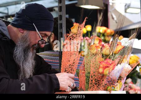 220424 -- BARCELONA, 24. April 2022 -- Ein Mann wählt Rosen in Barcelona, Spanien, 23. April 2022. St. George's Day sieht in der Regel die Straßen Barcelonas voller Umzüge von Menschen, die Bücher und Blumen mit ihren Lieben austauschen. SPANIEN-BARCELONA-SAINT GEORGE S TAG MENGXDINGBO PUBLICATIONXNOTXINXCHN Stockfoto
