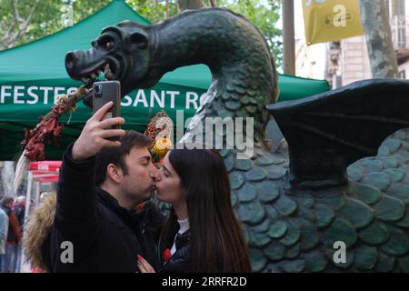 220424 -- BARCELONA, 24. April 2022 -- Ein Paar macht Selfie in Barcelona, Spanien, 23. April 2022. St. George's Day sieht in der Regel die Straßen Barcelonas voller Umzüge von Menschen, die Bücher und Blumen mit ihren Lieben austauschen. SPANIEN-BARCELONA-SAINT GEORGE S TAG MENGXDINGBO PUBLICATIONXNOTXINXCHN Stockfoto