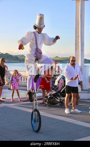 Bambolea Zirkus-Darsteller auf einem öffentlichen Hocheinrad-Event auf Stelzen und in weißen Kostümen in der Nähe von Piquio Sardinero Santander Cantabria Spanien Stockfoto