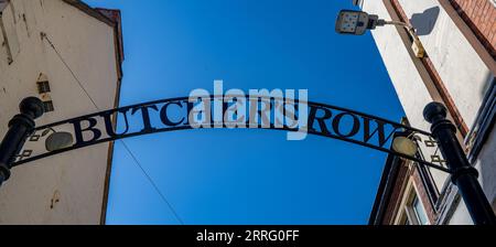 Butchers Row Grantham Lincolnshire – Ein traditionelles Metallschild über dem Kopf, wenn Sie die Straße vor einem blauen Sommerhimmel betreten Stockfoto