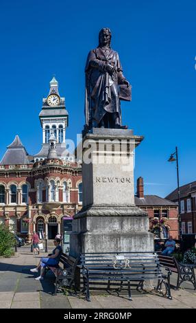 St Peters Hill Grantham Lincolnshire – Statue von Sir Isaac Newton, der in der Stadt zur Schule ging, vor einem Sommerhimmel mit der Town Guildhall im Hintergrund Stockfoto