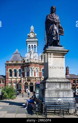 St Peters Hill Grantham Lincolnshire – Statue von Sir Isaac Newton, der in der Stadt zur Schule ging, vor einem Sommerhimmel mit der Town Guildhall im Hintergrund Stockfoto