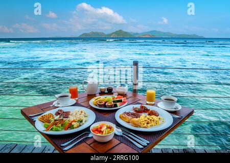 Frühstück am Strand am Pool mit Blick auf das Meer der La Digue Seychellen, tropische Insel Stockfoto