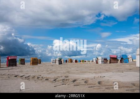 Strandleben am feinen Sandstrand von Norddorf auf der Nordseeinsel Amrum mit dramatischen Wolkenformationen Stockfoto