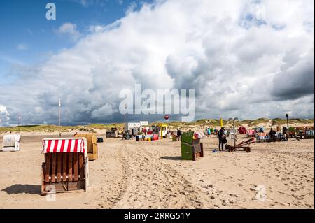 Strandleben am feinen Sandstrand von Norddorf auf der Nordseeinsel Amrum ein Windsurfer unter der Dusche Stockfoto
