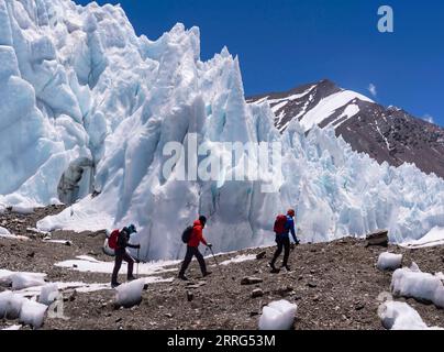 220509 -- MOUNT QOMOLANGMA BASE CAMP, 9. Mai 2022 -- Aktenfoto zeigt Dechen Ngodrup 1st R, der am Rongbuk-Gletscher auf Mount Qomolangma vorbeigeht, 21. Mai 2019. Am Mittwoch erreichten 13 Mitglieder eines chinesischen Expeditionsteams den Gipfel des höchsten Gipfels der Welt auf einer Höhe von 8.848,86 Metern. Das Team errichtete eine automatische meteorologische Überwachungsstation auf einer Höhe von 8.830 Metern, der höchsten ihrer Art. Sie haben auch die Dicke von Eis und Schnee mit hochpräzisem Radar gemessen und Proben für weitere Untersuchungen am Gipfel gesammelt. Dechen Ngodrup, Chef der Gruppe, die hatte Stockfoto