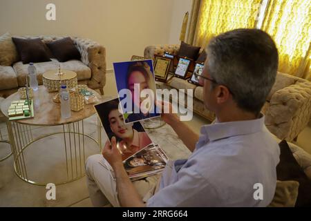 220510 -- GAZA, 10. Mai 2022 -- der Palästinenser Rami al-Afranji, dessen Frau und vier Kinder bei einem israelischen Bombenanschlag getötet wurden, hält Bilder seiner Kinder in seinem Haus in Gaza City am 10. Mai 2022. Während des Konflikts im Mai 10-21 im vergangenen Jahr starben bei den israelischen Bombenanschlägen mehr als 260 Palästinenser, darunter Frauen und Kinder. In der Zwischenzeit wurden etwa 14 Israelis infolge der Angriffe der Hamas auf israelische Städte getötet. Foto von /Xinhua TO GO WITH Feature: Ein Jahr nach dem israelisch-palästinensischen Konflikt, Schmerzen für palästinensische Opfer Familien MIDEAST-GAZA STADT-ISRAELISCH-PALÄSTINENSISCHE KONFLIKT-VIC Stockfoto