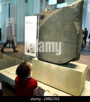 220512 -- LONDON, 12. Mai 2022 -- am 11. Mai 2022 beobachtet Ein Junge den Rosetta Stone im British Museum in London. Der Rosetta-Stein ist eines der berühmtesten Objekte im British Museum. Der Stein ist ein gebrochener Teil einer größeren Steinplatte. Es hat eine Nachricht, die in drei Arten von Schrift geschrieben ist. Es war ein wichtiger Hinweis, der Experten half, ägyptische Hieroglyphen zu lesen, ein Schriftsystem, das Bilder als Zeichen verwendete. GROSSBRITANNIEN-LONDON-BRITISH MUSEUM-KULTUR- UND KREATIVPRODUKT LIXYING PUBLICATIONXNOTXINXCHN Stockfoto