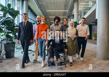In einem geräumigen und modernen Startup-Büro arbeitet eine vielfältige Gruppe von Geschäftskollegen, einschließlich eines Kollegen im Rollstuhl, zusammen und interagiert Stockfoto