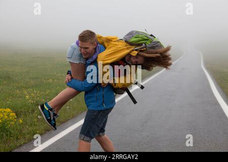 Junger Mann schwingt Mädchen auf der Straße herum Stockfoto