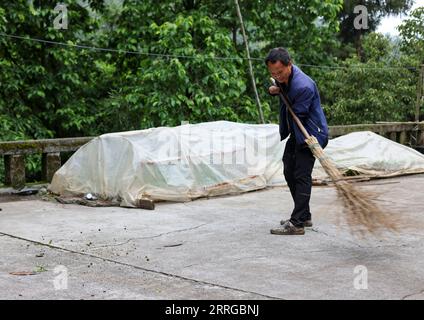 220516 -- ZUNYI, 16. Mai 2022 -- Zhao Youliang reinigt den Innenhof seines Hauses in der Gemeinde Zhongguan, Kreis Zheng an, Provinz Guizhou im Südwesten Chinas, 12. Mai 2022. Zhao Youliang und Jian Qin leben tief in den Bergen in Zunyi der Provinz Guizhou und sind ein Paar mit Behinderungen. Der 50-jährige Zhao verlor seine Hände durch eine Amputation in jungen Jahren, und die 43-jährige Jian verlor ihre Sehkraft wegen der Verzögerung bei der Behandlung einer Krankheit in ihrer Kindheit. Im Alltag hilft Zhao seiner Frau mit den Augen zu sehen, während Jian ihrem Mann mit den Händen hilft. Das Paar war suppo Stockfoto