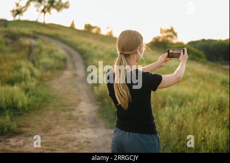 Frau auf dem Spaziergang hält an, um ein Video von der Naturlandschaft zu machen Stockfoto