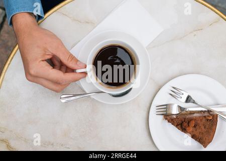 Blick auf den Himmel auf eine Tasse Kaffee und einen Kuchen auf einem Tisch Stockfoto