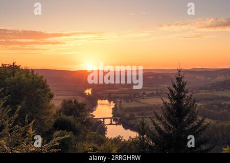 Sonnenuntergang über der Brücke Cénac-et-Saint-Julien über den Fluss Dordogne und das Tal in der Region Nouvelle-Aquitaine in Frankreich Stockfoto