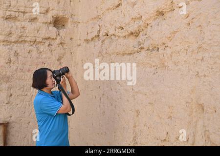 220526 -- ÜRÜMQI, 26. Mai 2022 -- Gulibekge Maiming Reheman macht Fotos in der alten Stadt Jiaohe, Turpan, Nordwestchinas autonome Region Xinjiang Uygur, 20. Mai 2022. Gulibekge Maiming Reheman ist ein Konservator der kulturellen Schatztruhe der Ruinen von Jiaohe, der weltweit größten und am besten erhaltenen Relikte einer aus Ton gebauten Stadt in Turpan, Nordwestchinas autonomer Region Xinjiang Uygur. Seit 1972 widmet sich Gulibekges Großvater, Vater und jetzt selbst dem Schutz der antiken Stadt Jiaohe. Sie haben hier gelebt, gearbeitet und ihre Kinder großgezogen und haben eine tiefe Verbindung zu ihr aufgebaut Stockfoto