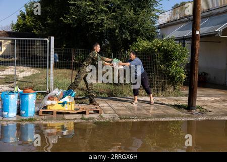 Karditsa, Griechenland. September 2023. Ein griechischer Soldat verteilt Wasserflaschen im überfluteten Dorf Palamas nahe der Stadt Karditsa in Mittelgriechenland. Die Zahl der Todesopfer durch Überschwemmungen, die durch sintflutartige Regenfälle in Zentralgriechenland verursacht wurden, ist weiter gestiegen. Quelle: Yorgos Karahalis/dpa/Alamy Live News Stockfoto