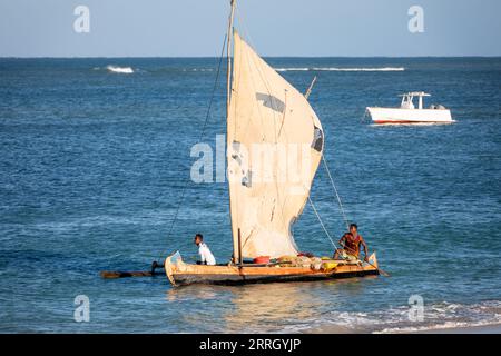 ANAKAO, MADAGASKAR - 23. NOVEMBER 2022: Fischer, die vor der Küste von Anakao ein aus Baumstämmen geschnitztes Auslegerkanu zum Fischen verwenden. Die primäre Quelle von Stockfoto
