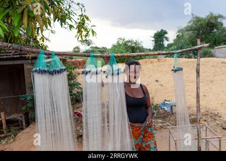 Miandrivazo, Madagaskar - 1. November 2022: Eine madagassische Frau, die Fischernetze verkauft, hängt an einem Holzstab. Stockfoto