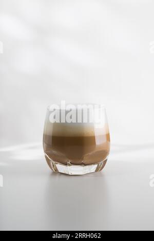 Geeister Cappuccino in einem Plastikglas auf einem weißen Holztisch Stockfoto