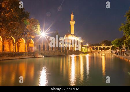 Sanliurfa, Türkei - 19. Juni 2023 : Balıklıgöl (Balık-See) und Rizvaniye-Moschee in wunderschöner Sonnenuntergangslandschaft in Şanlıurfa, Türkei. Stockfoto