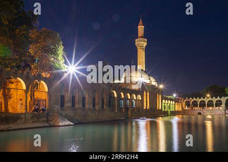 Sanliurfa, Türkei - 19. Juni 2023 : Balıklıgöl (Balık-See) und Rizvaniye-Moschee in wunderschöner Sonnenuntergangslandschaft in Şanlıurfa, Türkei. Stockfoto