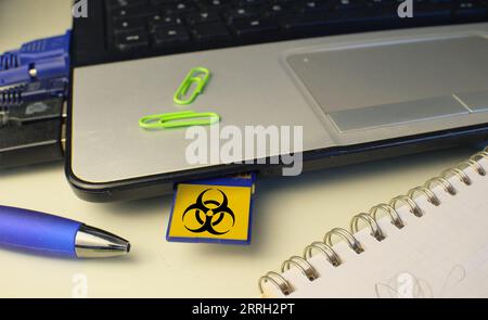 Infektion eines Laptops mit einem Computervirus über eine Speicherkarte, Computervirenangriff, Hacking, Malware, Computerkriminalität Konzept. Stockfoto