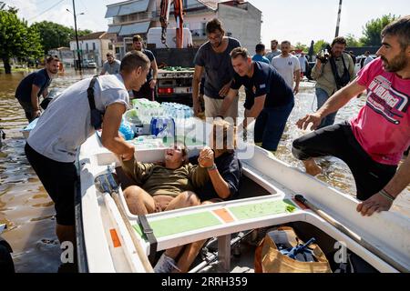 Karditsa, Griechenland. September 2023. Anwohner helfen einem jungen Mann und seiner Mutter im überfluteten Dorf Palamas nahe der Stadt Karditsa in Zentralgriechenland. Die Zahl der Todesopfer durch Überschwemmungen, die durch sintflutartige Regenfälle in Zentralgriechenland verursacht wurden, ist weiter gestiegen. Quelle: Yorgos Karahalis/dpa/Alamy Live News Stockfoto