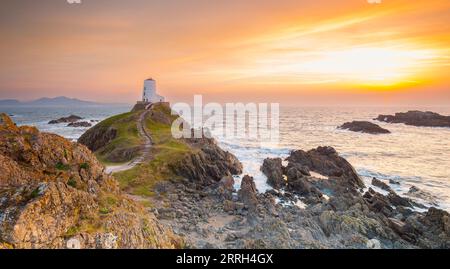 TWR Mawr Lighthouse, Ynys Llanddwyn, Anglesey, Nordwales, Großbritannien mit dramatischem Winteruntergang über der Menai Strait. Stockfoto